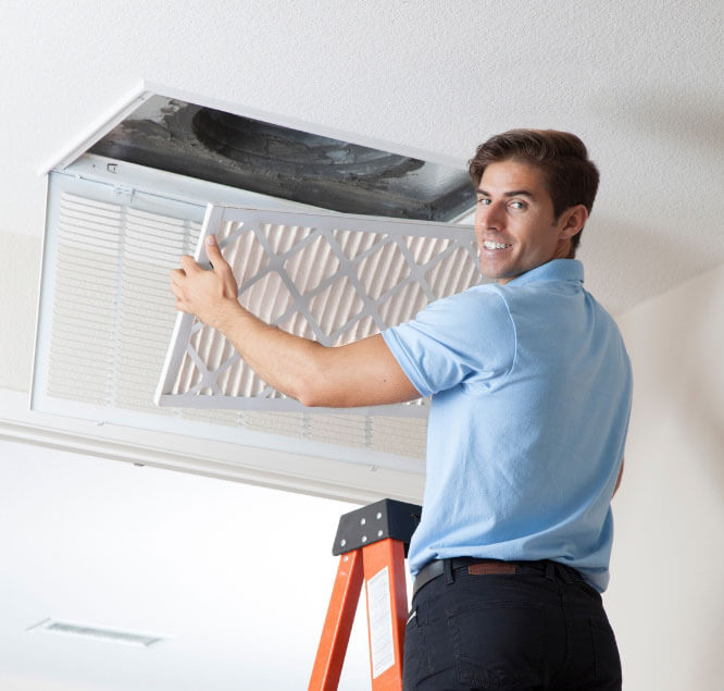 A technician changing an air filter to ensure optimal HVAC performance.